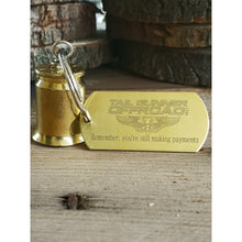 Load image into Gallery viewer, brass bell made of a .50 cal shell with brass tag that says "Remember, you'rre still making payments"