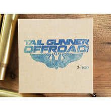 Load image into Gallery viewer, packaging for brass bell made of a .50 cal shell with brass tag that says &quot;Fun begins where pavement ends&quot;
