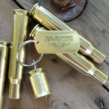 Load image into Gallery viewer, brass bell made of a .50 cal shell with brass tag that says &quot;Fun begins where pavement ends&quot;
